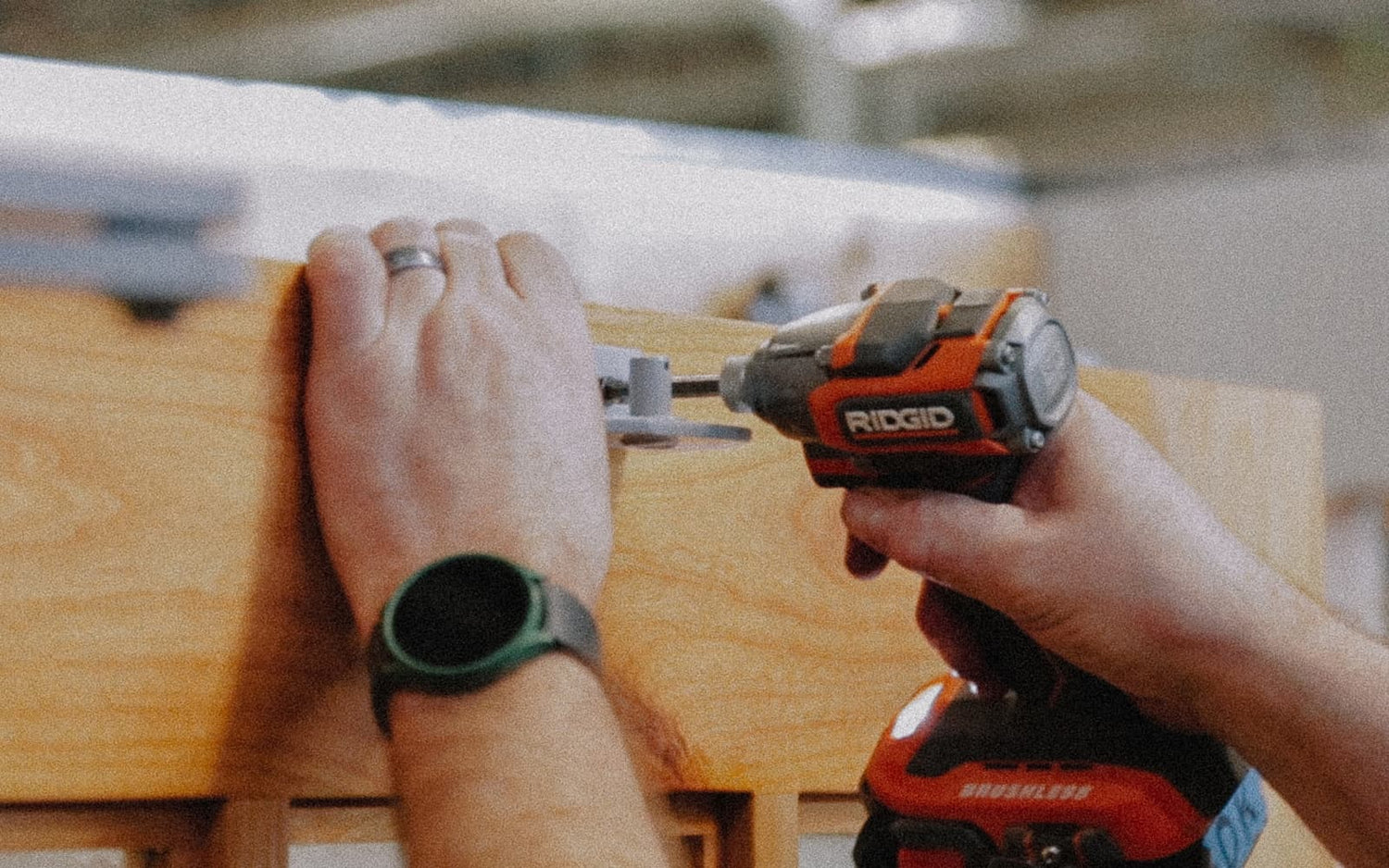 Hands drilling Franklin opener arm into the door