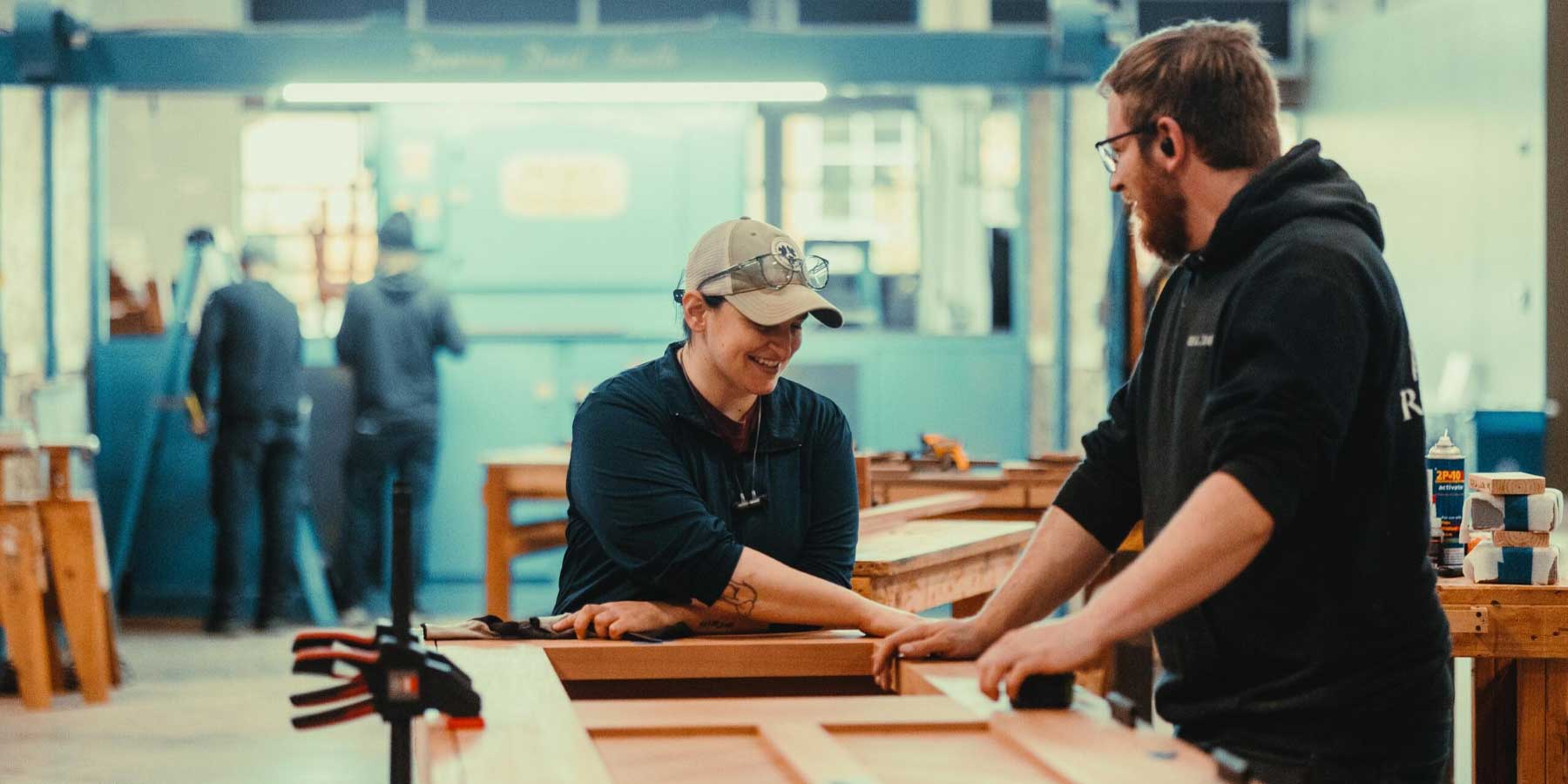 Craftsman and Craftswoman building a door and laughing