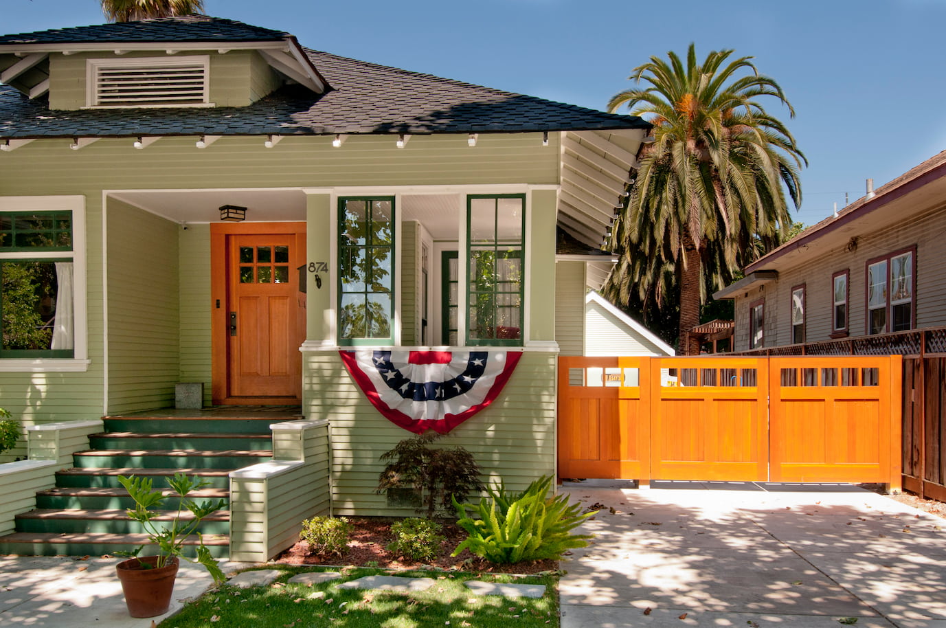 Wood front door and matching wooden gate on a green house