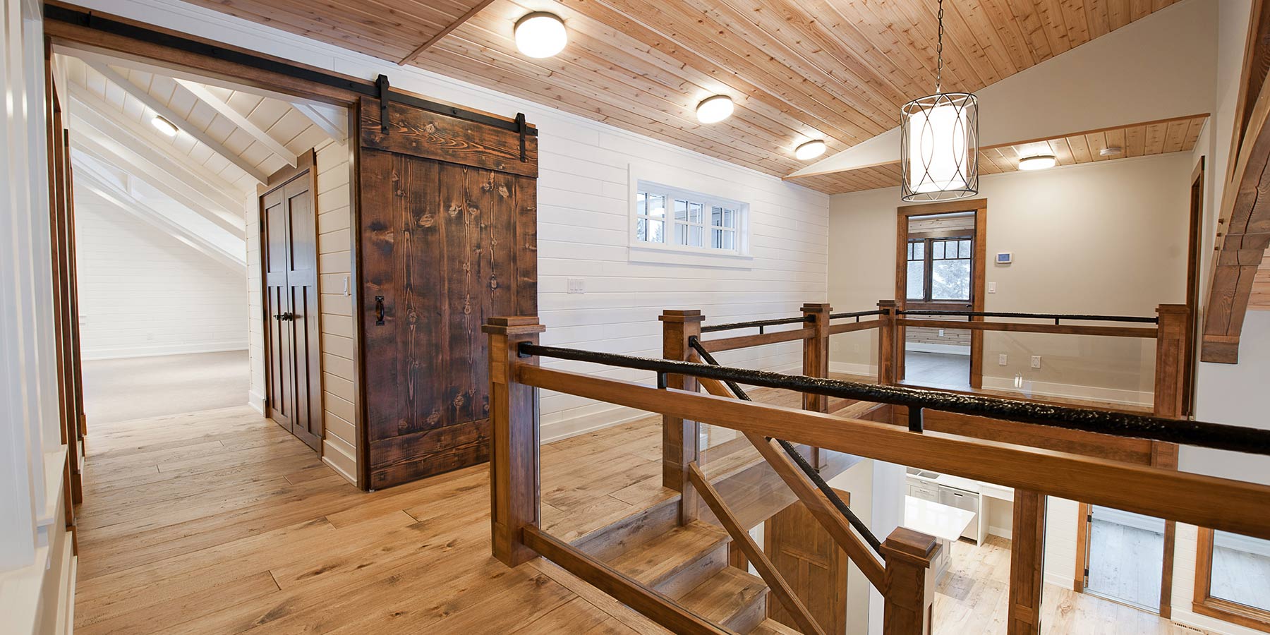 Rustic Knotty interior barn door next to stairs