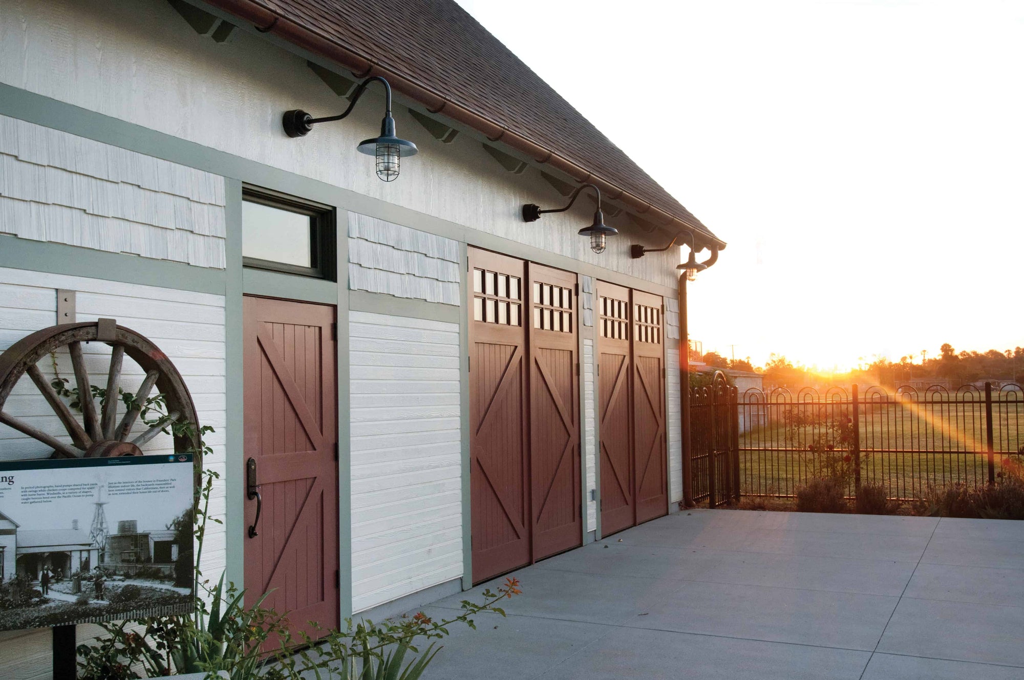 Two sets of red carriage doors and a matching entry door installed in a commercial building