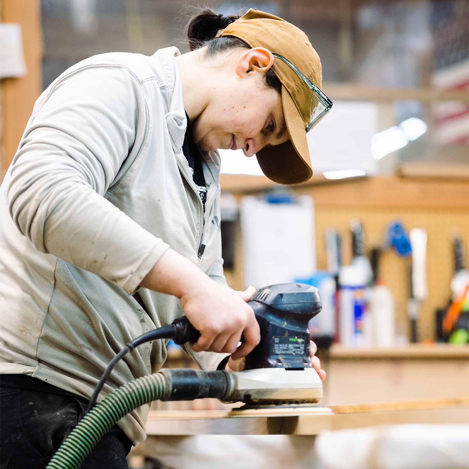 Craftswoman sanding a door at RealCraft's wood shop.