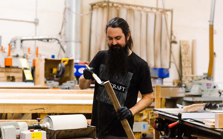 Craftsman applies glue to the edge of a piece of wood