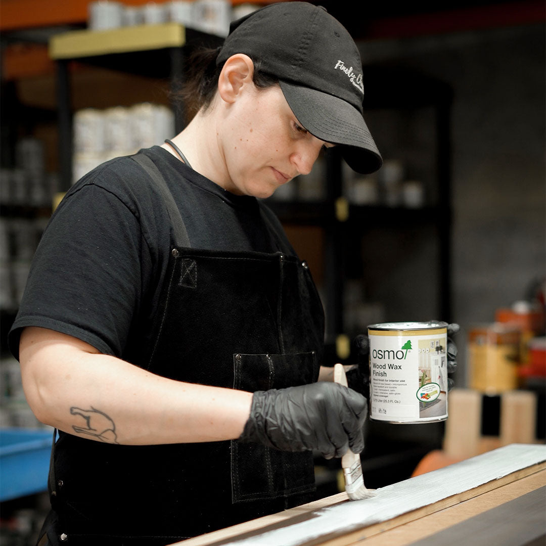 Craftswoman applying finish on wood