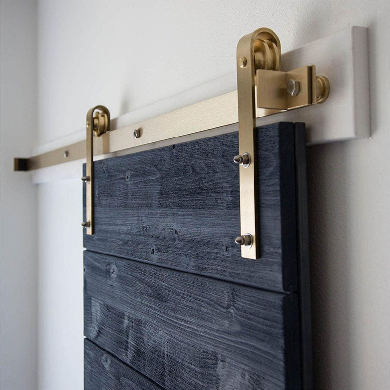 brass gold barn door hardware on a blue door