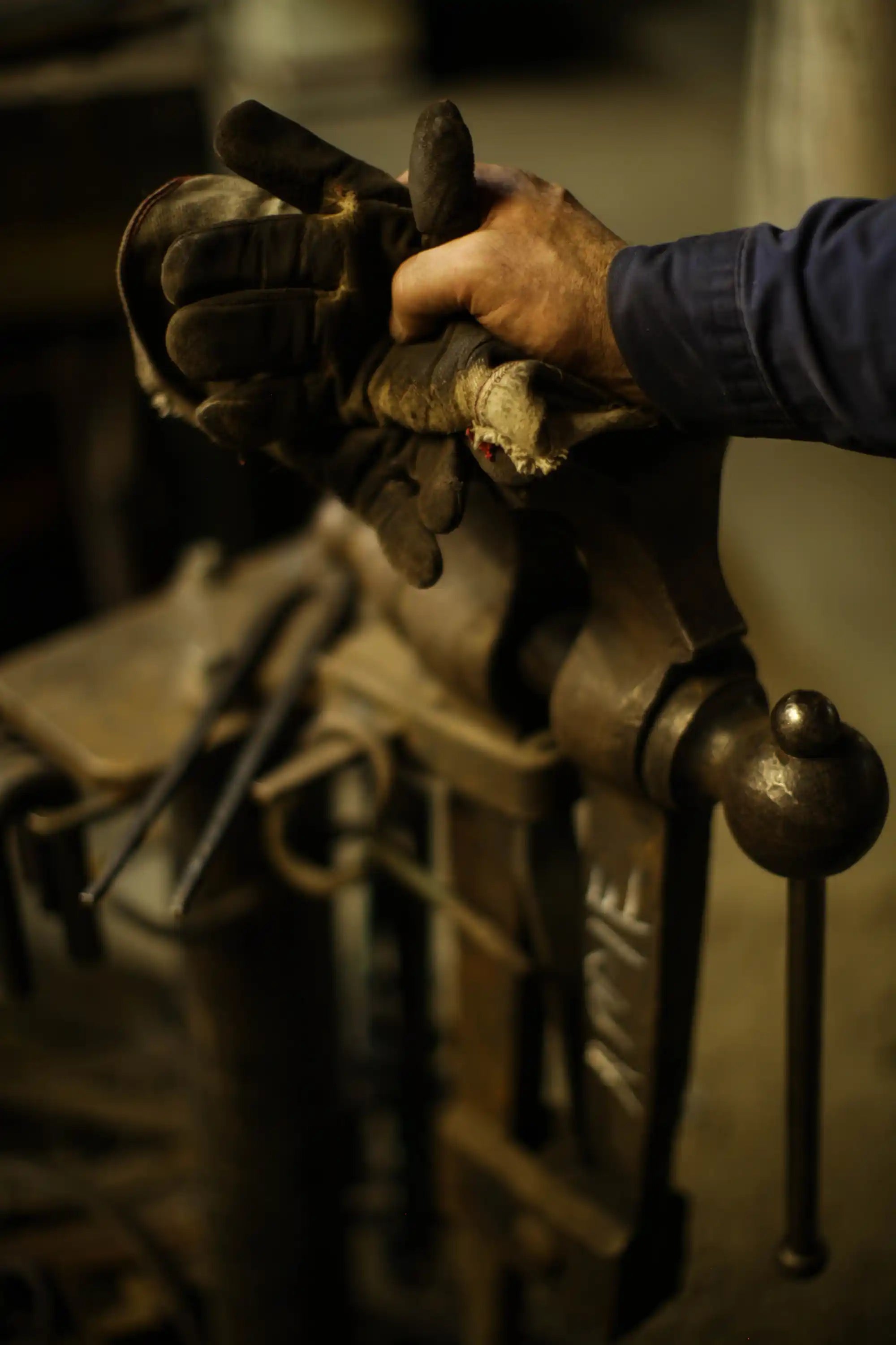 Blacksmith hands closeup shot next to his tools