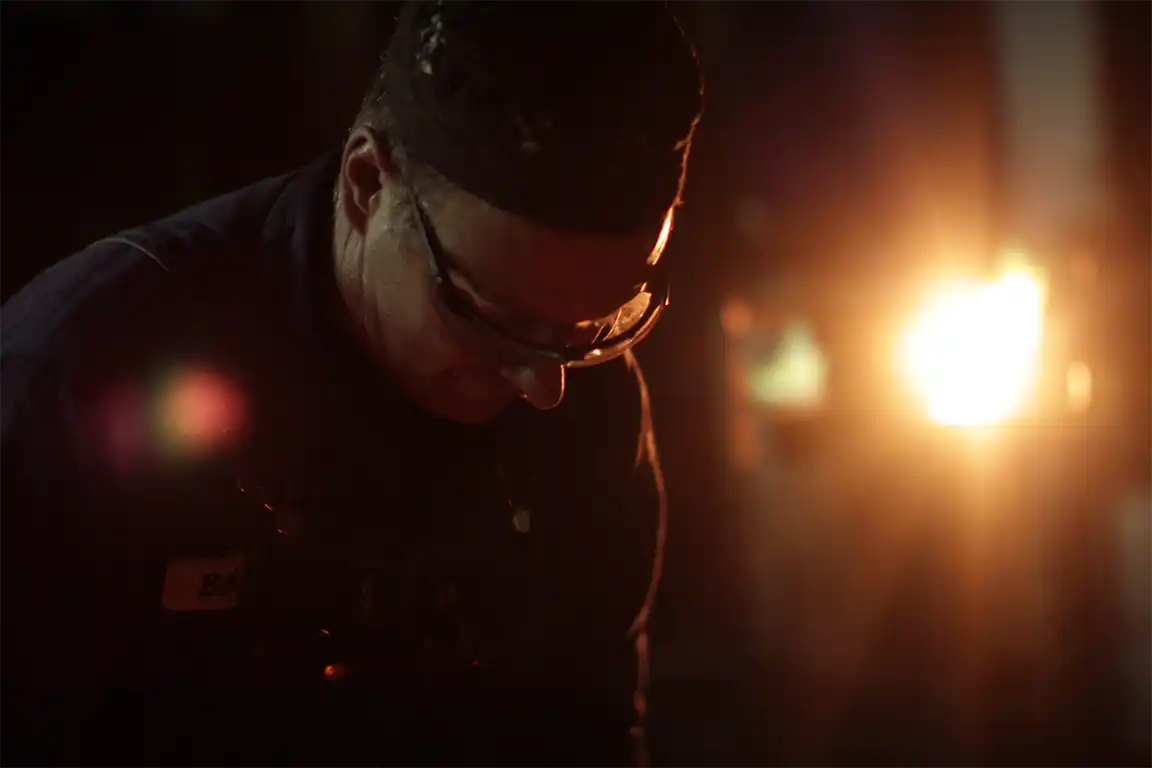 Blacksmith working with fire light on the background