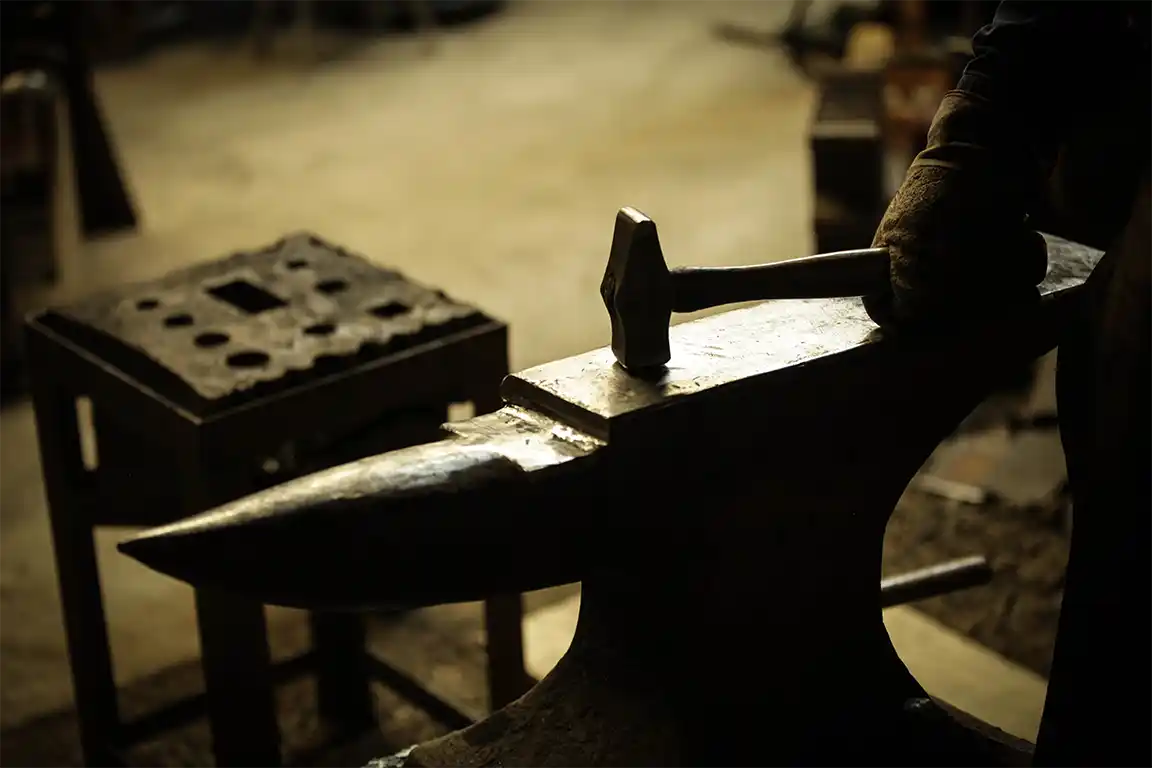 Blacksmith holding a hammer on top of an anvil