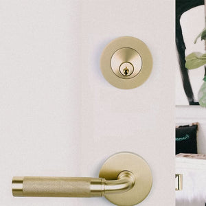 Modern Disc Keyed Deadbolt in brass in a white door