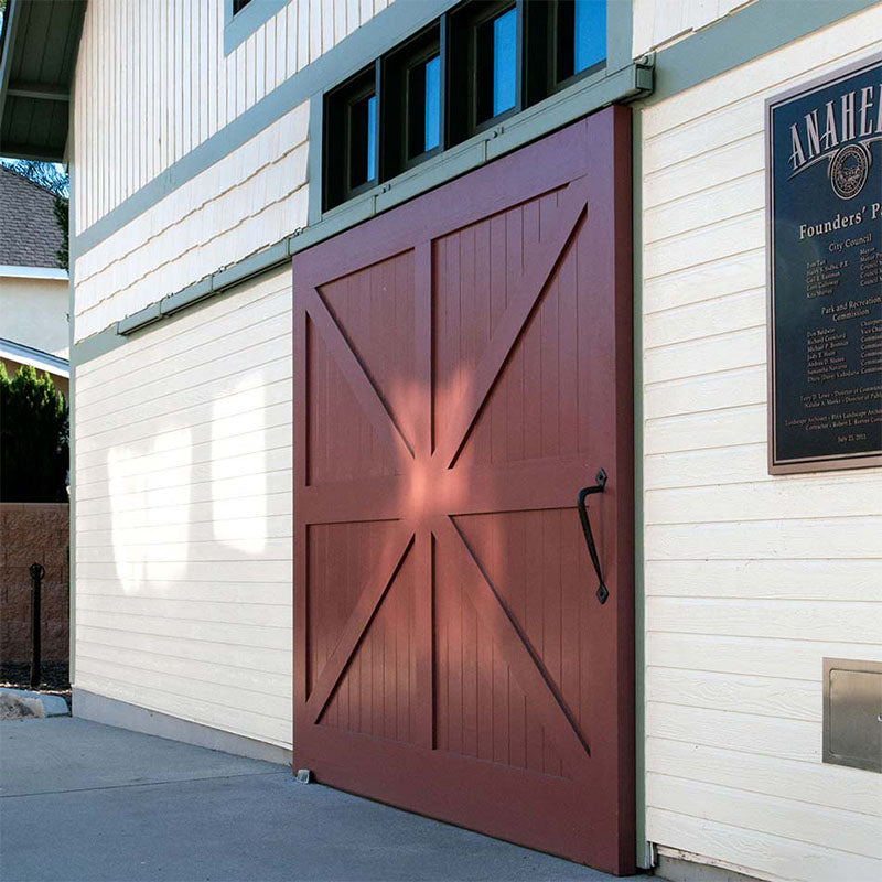 Red large sliding barn door with exterior barn door hardware