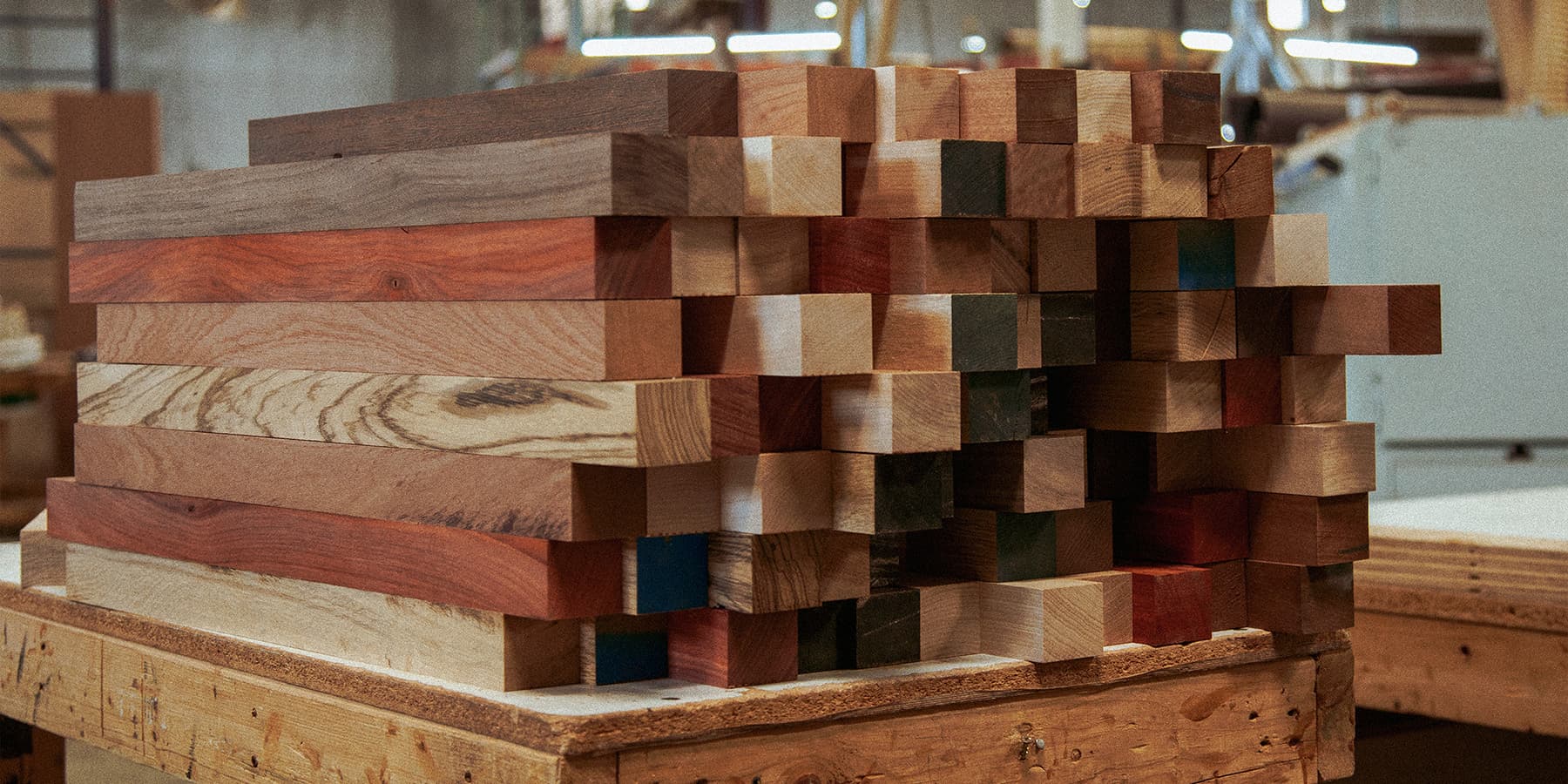 photo of several hardwood pieces in different colors stacked on cart on their way to be glued