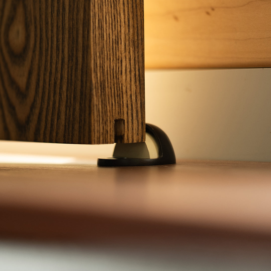 Bronze doorstop against the edge of a wooden door