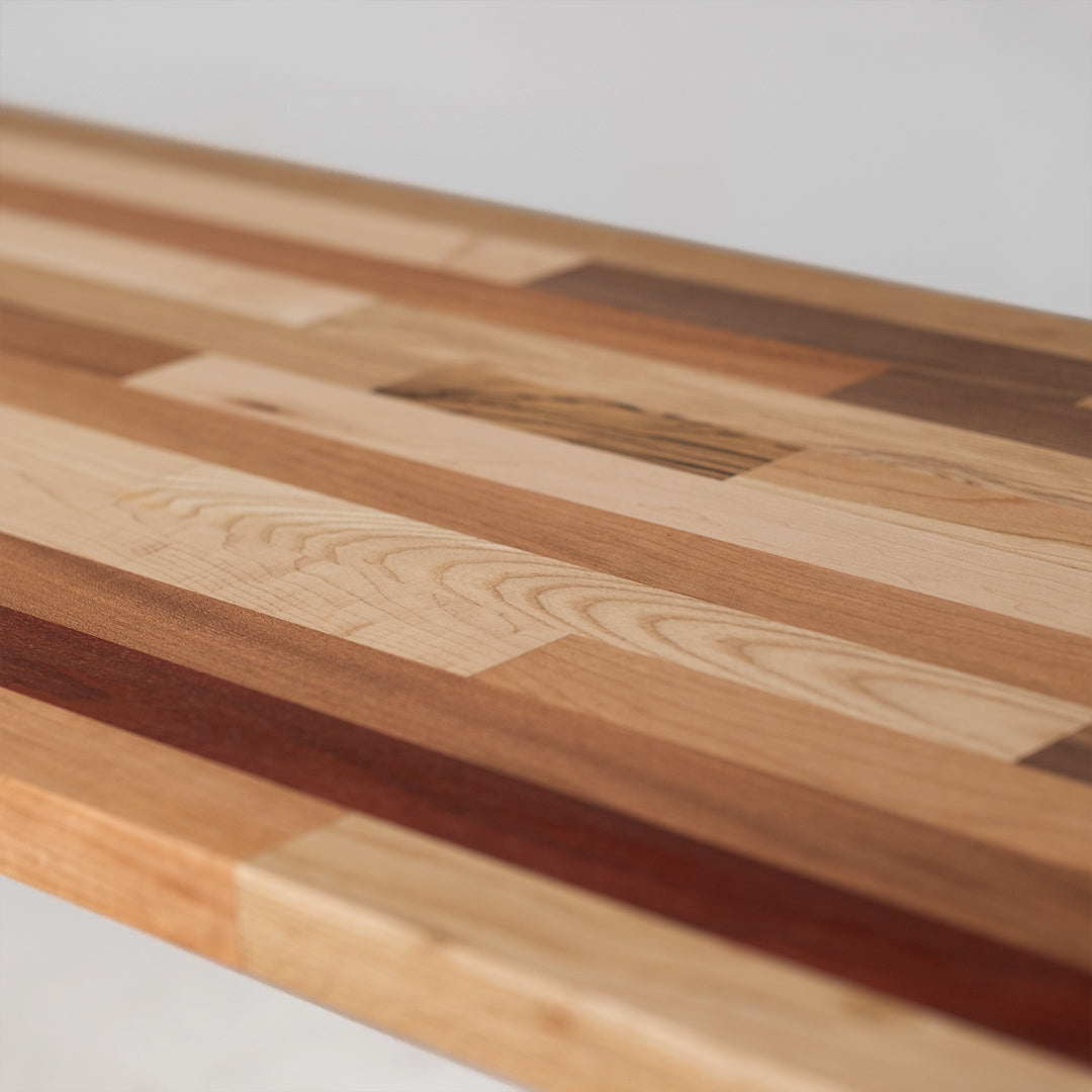 closeup photo of Palomino countertop showing Ash, Sapele, Zebrawood, Maple, and Padauk pieces