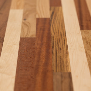 A long, horizontal wood wall art piece made of various solid colors and patterns in reds, browns, yellows, and other earth tones. The background is white with no shadows or textures on it. This artwork would be used as an accent for the dining room table, sitting under that wall art, and to match its color scheme.