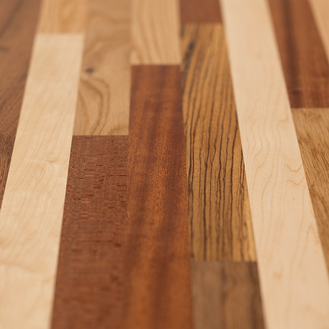 A long, horizontal wood wall art piece made of various solid colors and patterns in reds, browns, yellows, and other earth tones. The background is white with no shadows or textures on it. This artwork would be used as an accent for the dining room table, sitting under that wall art, and to match its color scheme.