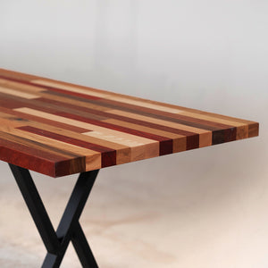 A long, horizontal wood wall art piece made of various solid colors and patterns in reds, browns, yellows, and other earth tones. The background is white with no shadows or textures on it. This artwork would be used as an accent for the dining room table, sitting under that wall art, and to match its color scheme.