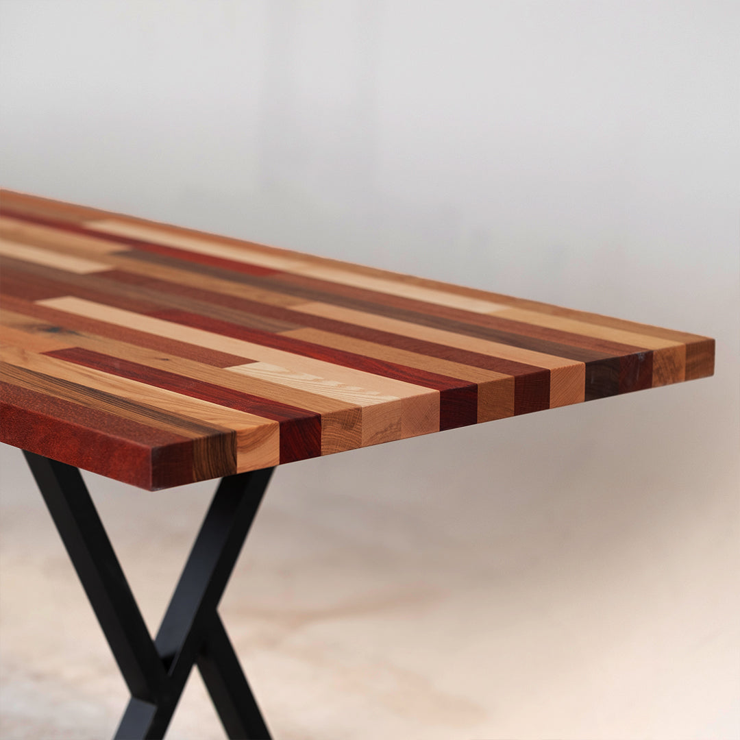 A long, horizontal wood wall art piece made of various solid colors and patterns in reds, browns, yellows, and other earth tones. The background is white with no shadows or textures on it. This artwork would be used as an accent for the dining room table, sitting under that wall art, and to match its color scheme.