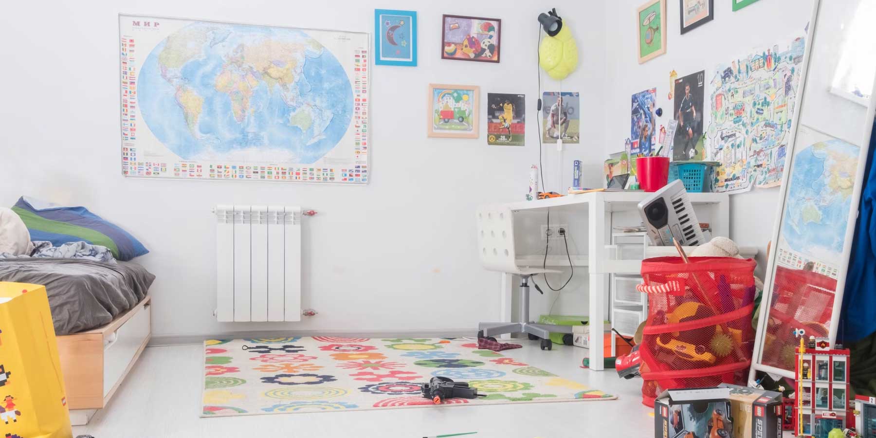 Kid's room with toys on the floor and a map on the wall