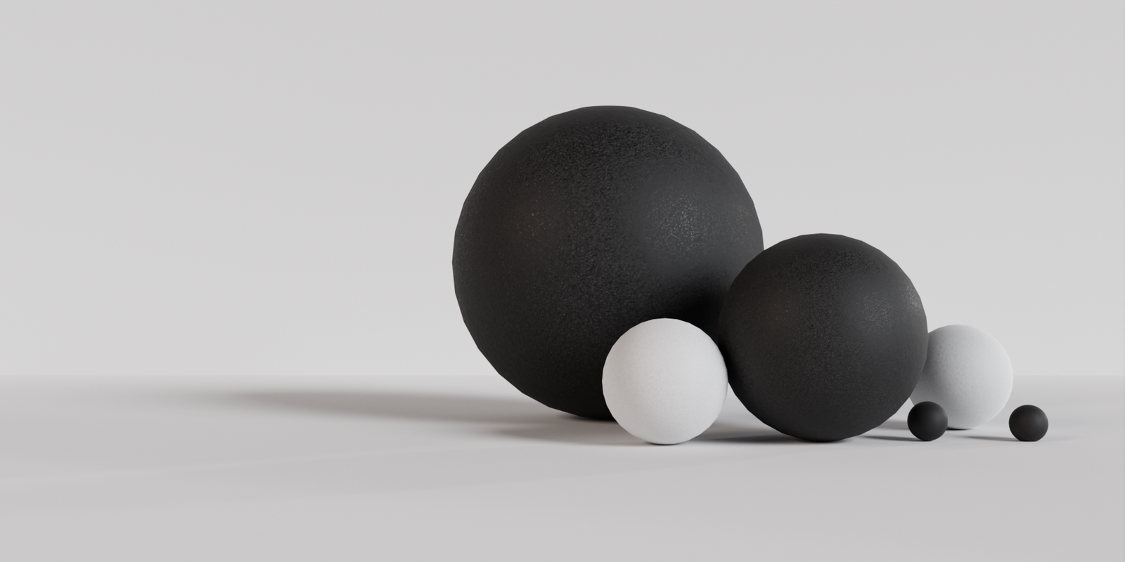 Black and white powder-coated balls on a white background with studio lighting setup.