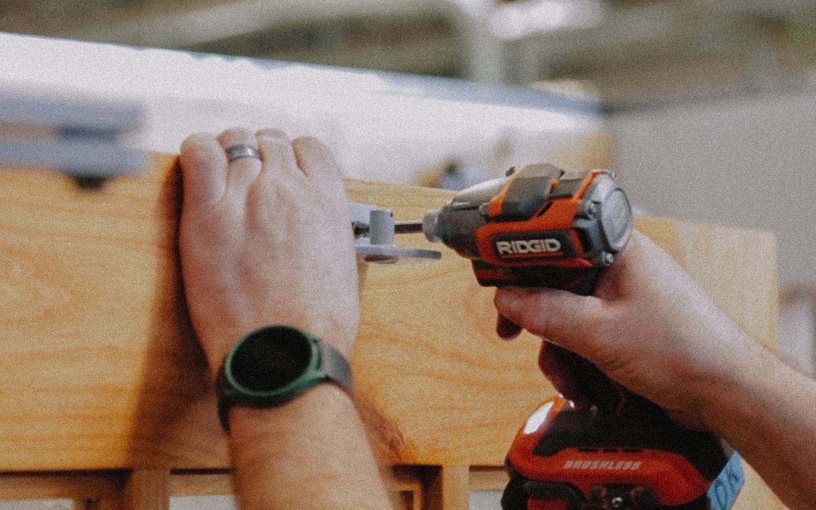 Hands drilling Franklin opener arm into the door