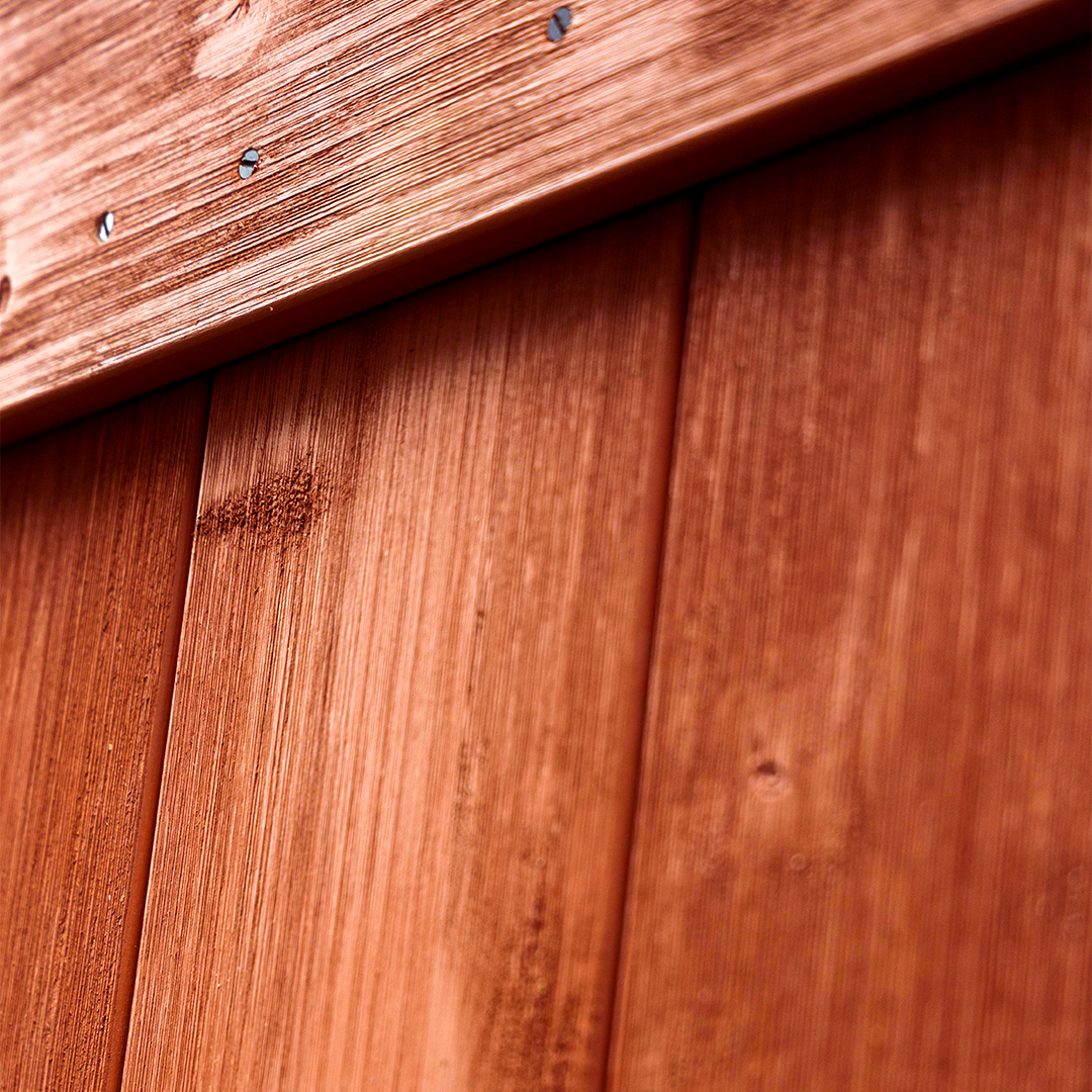 Detailed red weathered wood barn door planks close up