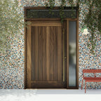 Monterey Single Panel Tongue and Groove  Pivot Door with sidelights and transom and a long brass handle in a colorful garden wall