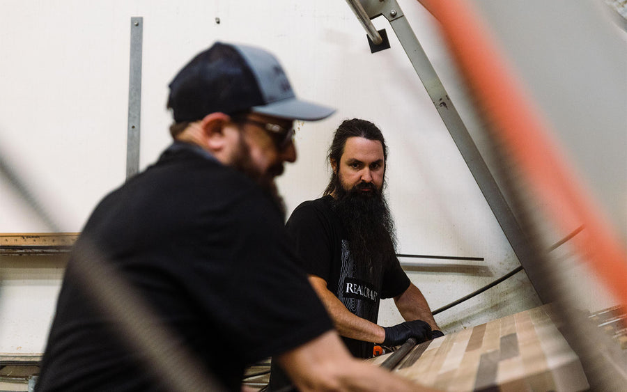 Craftsmen clamping countertop as it dries in glue rack