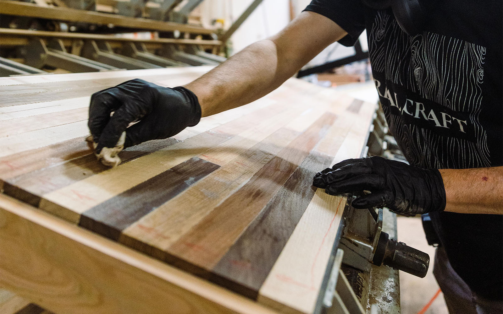 photo of craftsman with gloves applying wood finish to a custom hardwood variety countertop