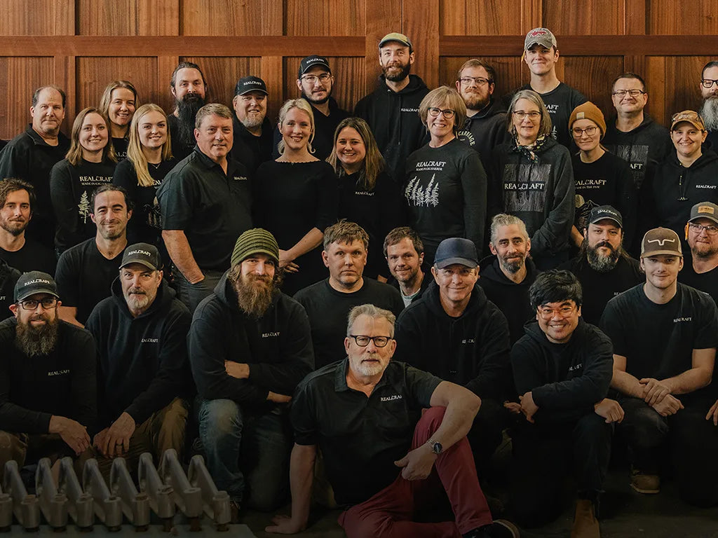 A group photo of employees with extremely large carriage doors behind them