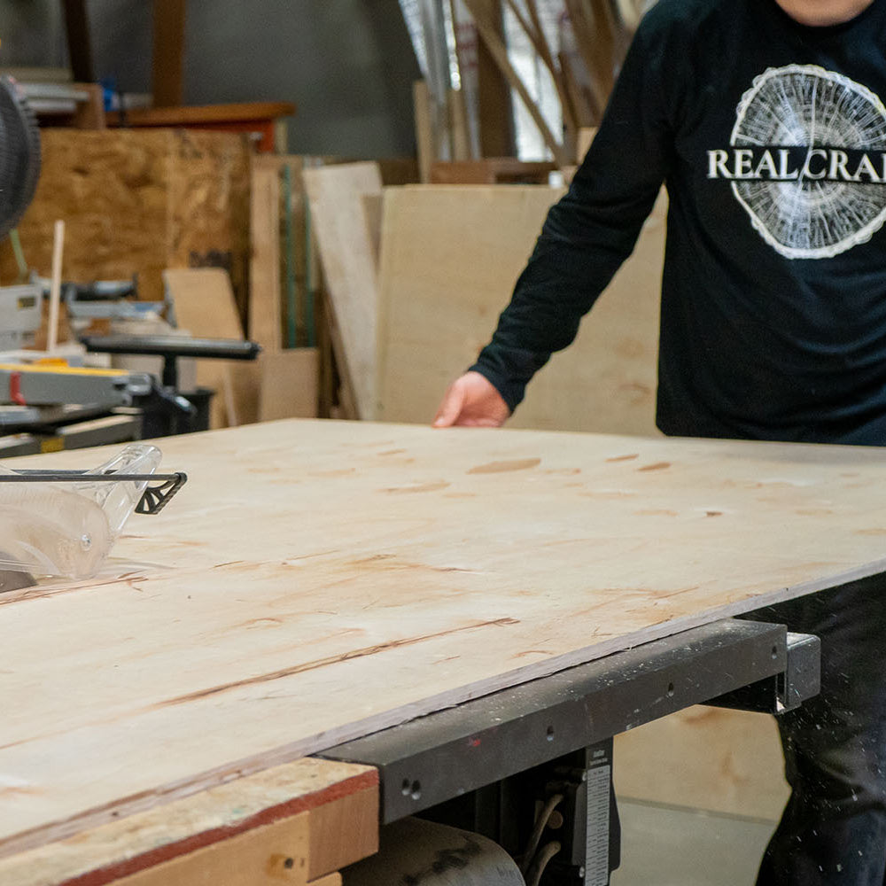 Craftsman cuts a sheet of plywood to build a shipping crate. 