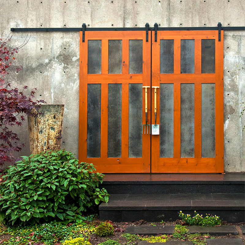Custom double exterior barn door on garden area