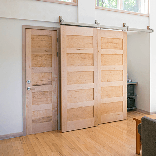 bypass beech wood barn door installed a living room space