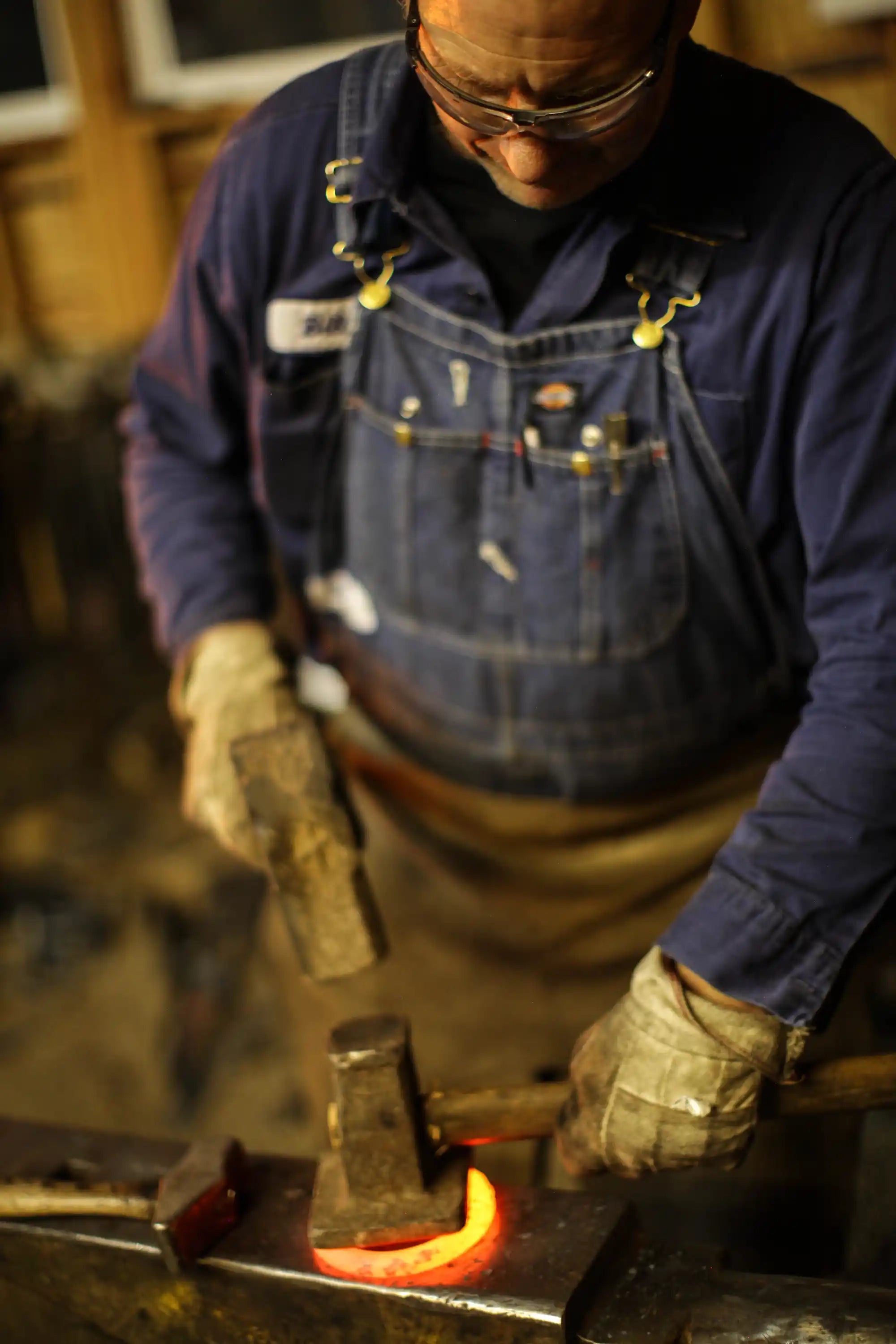 Blacksmith hammering a barn door handle
