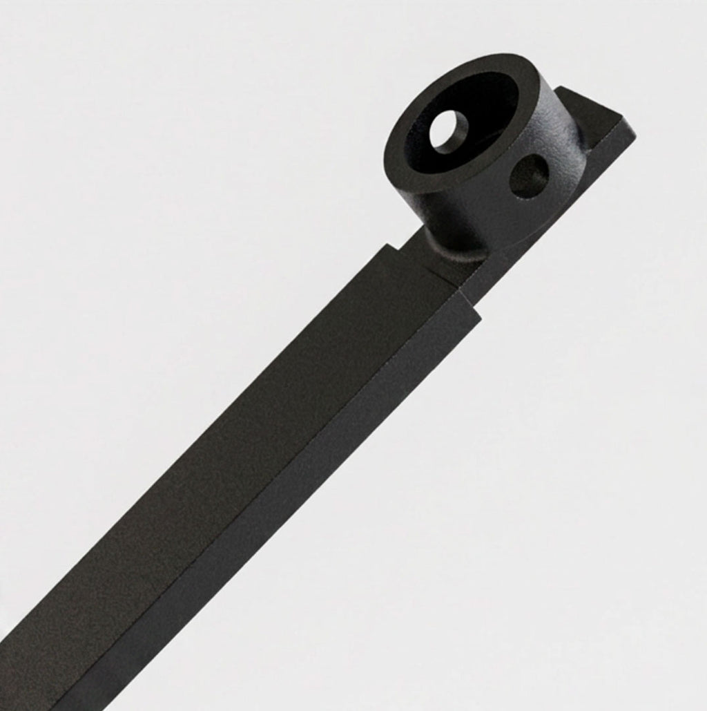A close-up of a matte black metal hardware component, likely a bracket or mounting piece, shown diagonally against a clean light gray background.