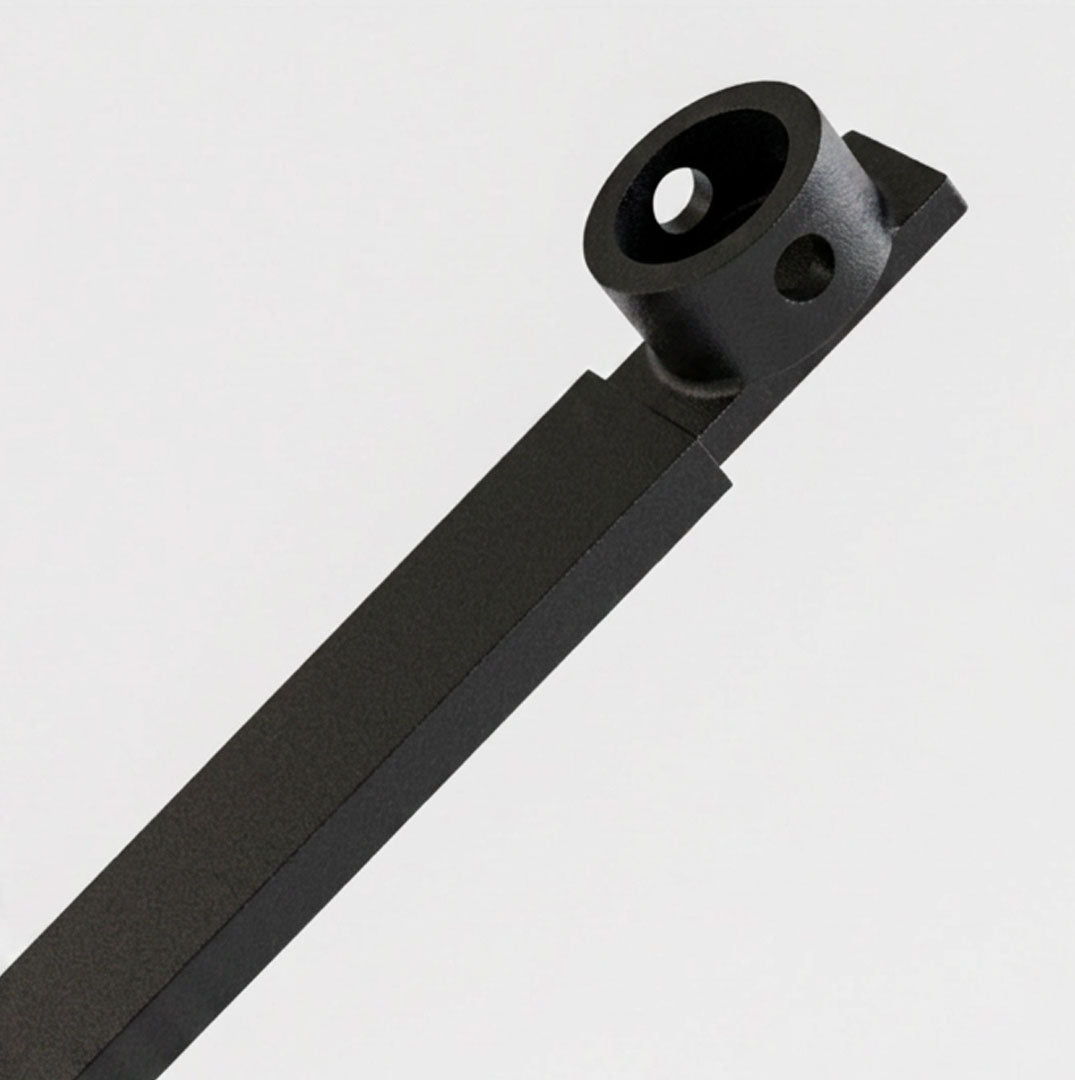 A close-up of a matte black metal hardware component, likely a bracket or mounting piece, shown diagonally against a clean light gray background.
