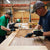 Two RealCraft employees applying wood finish to a door,