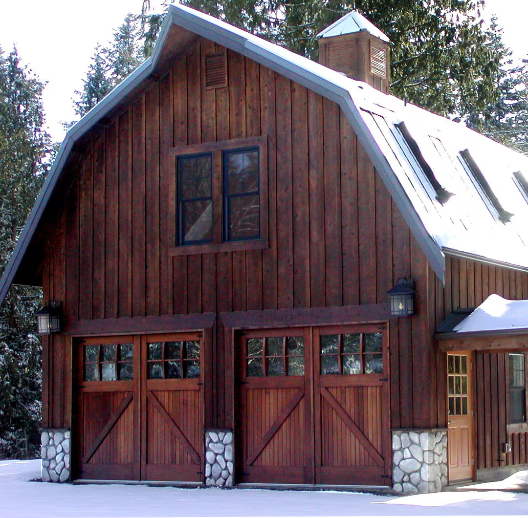 Double carriage garage doors with classic Z-brace detailing, shown on a residential exterior with a rustic, traditional appearance in daylight.