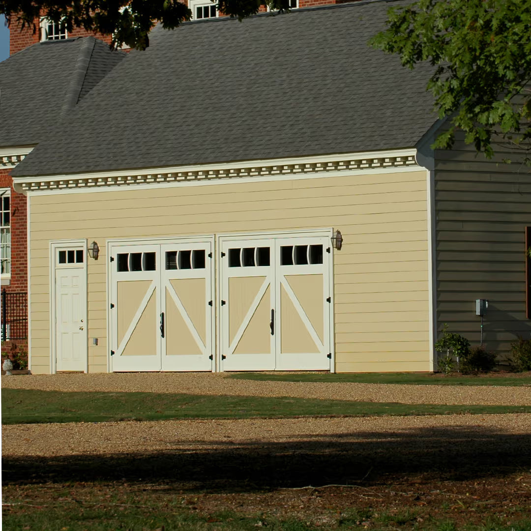 Duo-tone carriage garage door with a mid-brace design, shown on a residential exterior with contrasting panel finishes in daylight.