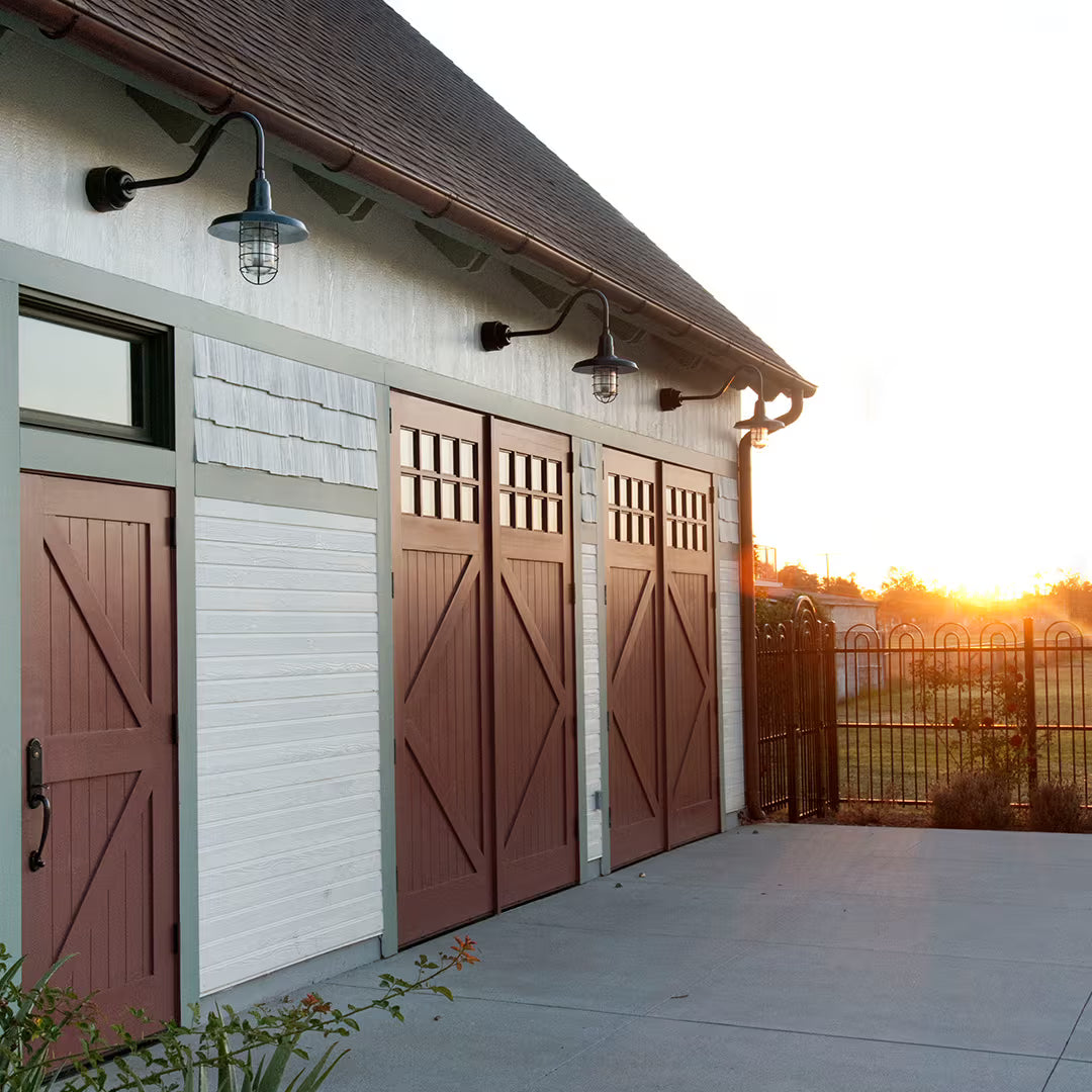 Set of Z-brace carriage garage doors installed side by side on a residential exterior, shown in natural daylight.
