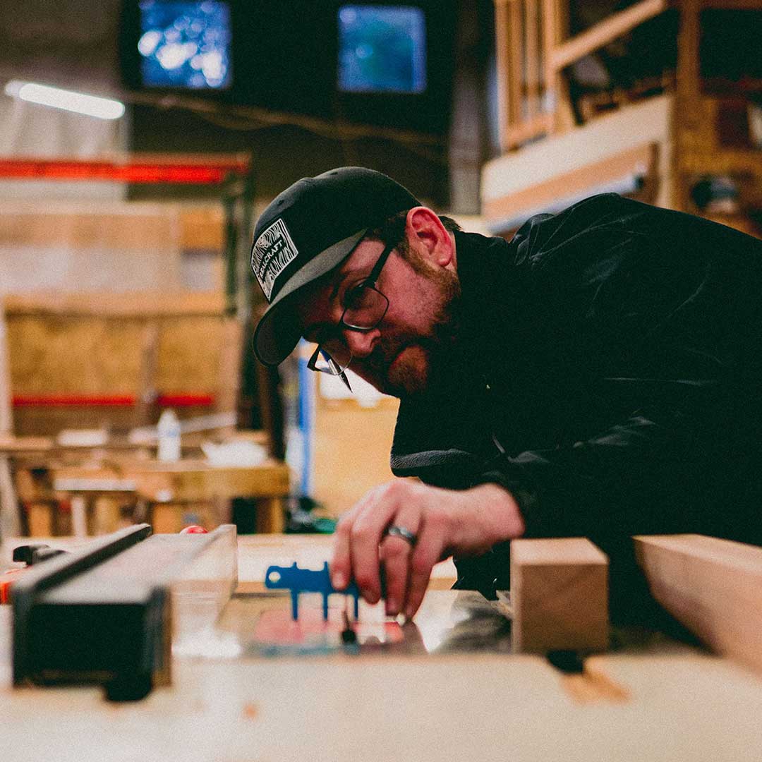 Man measuring wood on a woodshop. 