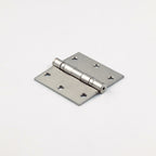 Metallic door hinge on a light pink background