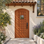 RealCraft San Marco arched door in Sapele Mahogany, with flat inset panels and a square window, beneath a continuous terracotta eave in a courtyard with citrus and lavender.