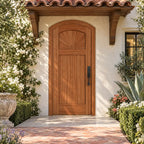 RealCraft Verona arched door in Sapele Mahogany, shown beneath a projecting roof overhang in a Mediterranean courtyard.